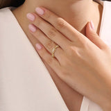 Model wears a 14k gold twisted band eternity ring featuring moissanite accents. A stylish and timeless statement piece for everyday wear.