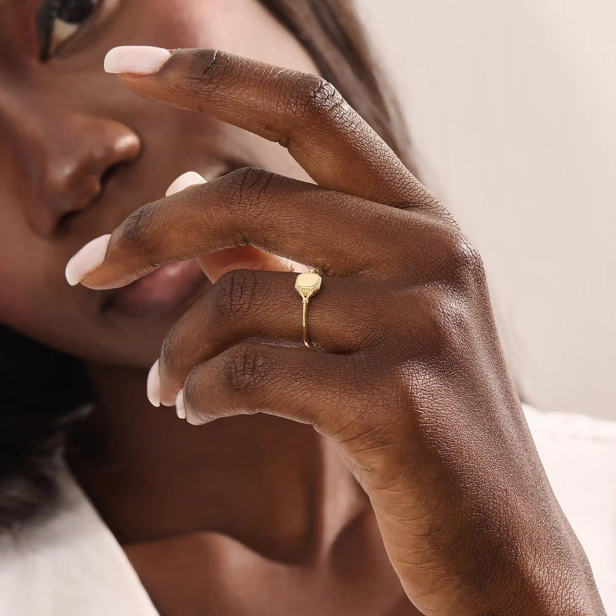 Model wears a 14k gold vintage square signet ring featuring intricate design elements. A bold and refined accessory for modern style.