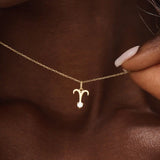 Model wears a 14k solid gold Aries zodiac symbol pendant necklace with clear moissanite, perfect for Aries astrology lovers.