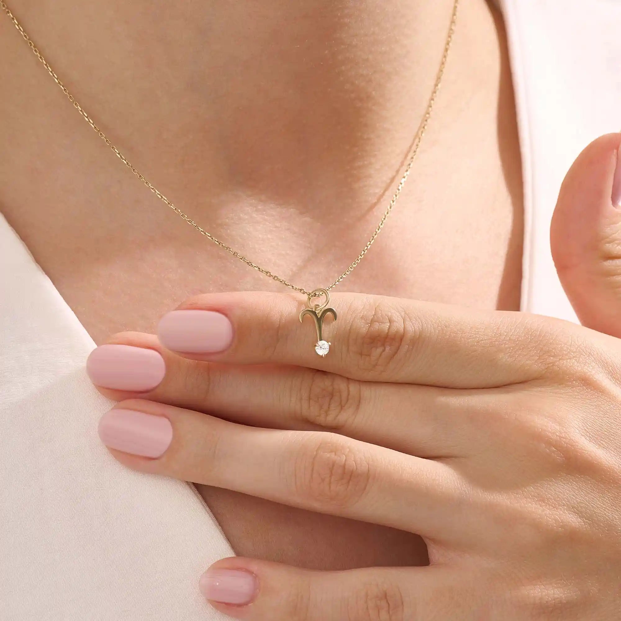 Model wears a 14k solid gold Aries zodiac symbol pendant necklace with clear moissanite, perfect for Aries astrology lovers.