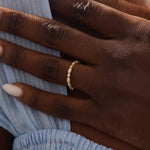 Model wears a 14k solid gold Art Deco-style stacking wedding ring featuring pave moissanites. Stylish and timeless design for modern brides.