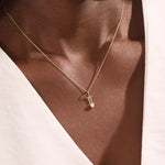 Model wears a 14k solid gold Gemini zodiac symbol pendant necklace with a natural pearl, perfect for astrology lovers.