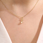 Model wears a 14k solid gold Gemini zodiac symbol pendant necklace with a natural pearl, perfect for astrology lovers.