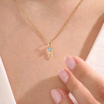 Model wears a 14k solid gold Pisces zodiac symbol pendant necklace with aquamarine, perfect for Pisces zodiac birthdays.