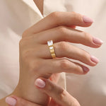 Model wears a 14k solid gold chunky Toi et Moi engagement ring with prong-set emerald-cut and half bezel-set round moissanites. Unique and striking statement piece for brides.