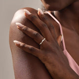 Model wears a 14k solid gold curved stackable wedding ring featuring cluster-pave moissanites. Elegant and versatile piece for layering or bridal wear.