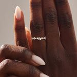 Model wears a 14k solid gold curved stackable wedding ring featuring cluster-pave moissanites. Elegant and versatile piece for layering or bridal wear.