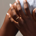 Model wears a 14k solid gold faceted band wedding ring featuring tiny moissanites. Elegant and versatile style for stacking or bridal jewelry.