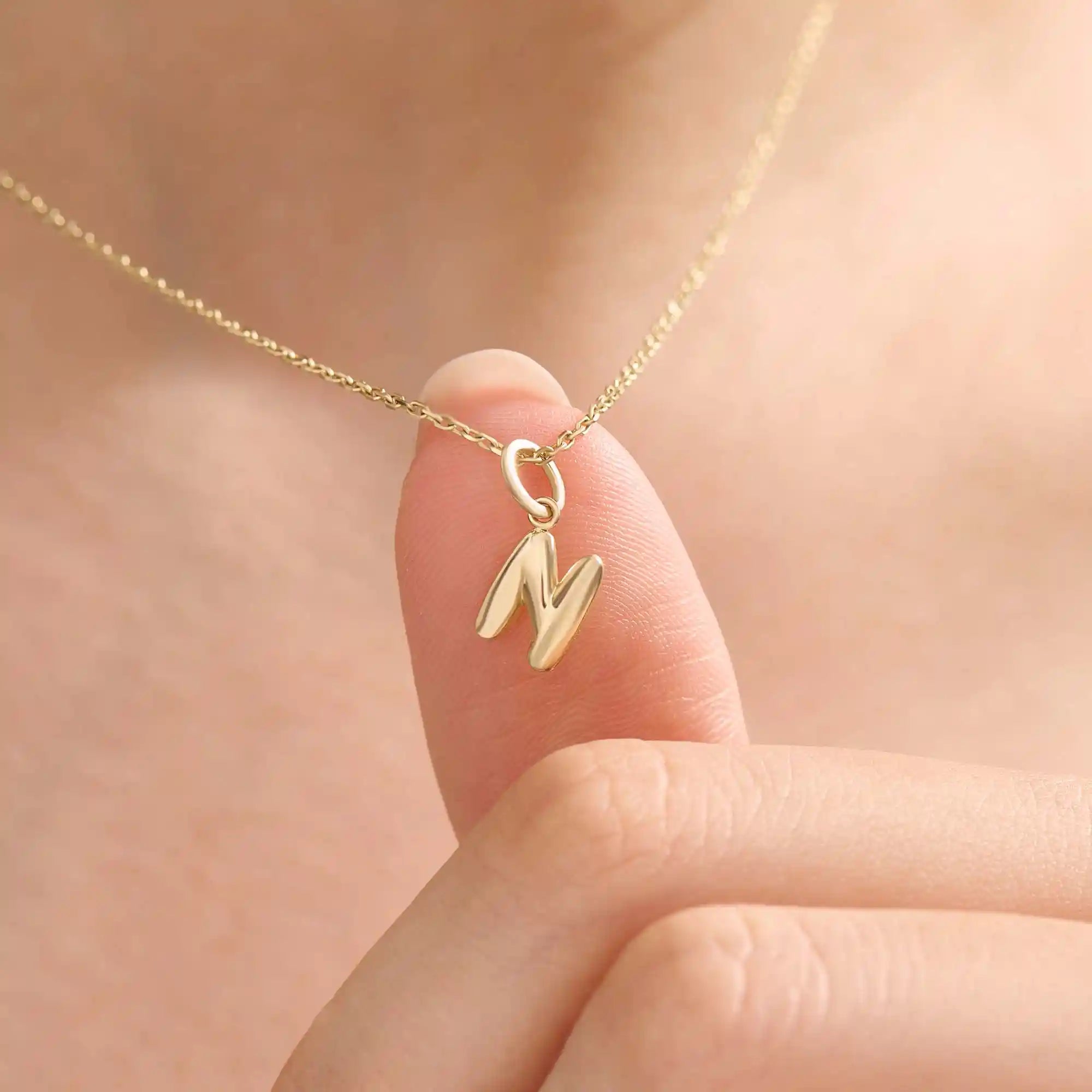 Model wears a 14k solid gold puffy letter necklace with a bold yet delicate look. The sculpted design adds a playful and personalized touch.