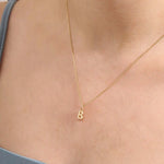 Model wears a 14k solid gold puffy letter necklace with a bold yet delicate look. The sculpted design adds a playful and personalized touch.