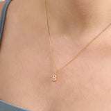 Model wears a 14k solid gold puffy letter necklace with a bold yet delicate look. The sculpted design adds a playful and personalized touch.