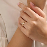 Model wears a bezel set princess square cut solitaire engagement ring in 14k solid gold. Minimalist and timeless bridal style.