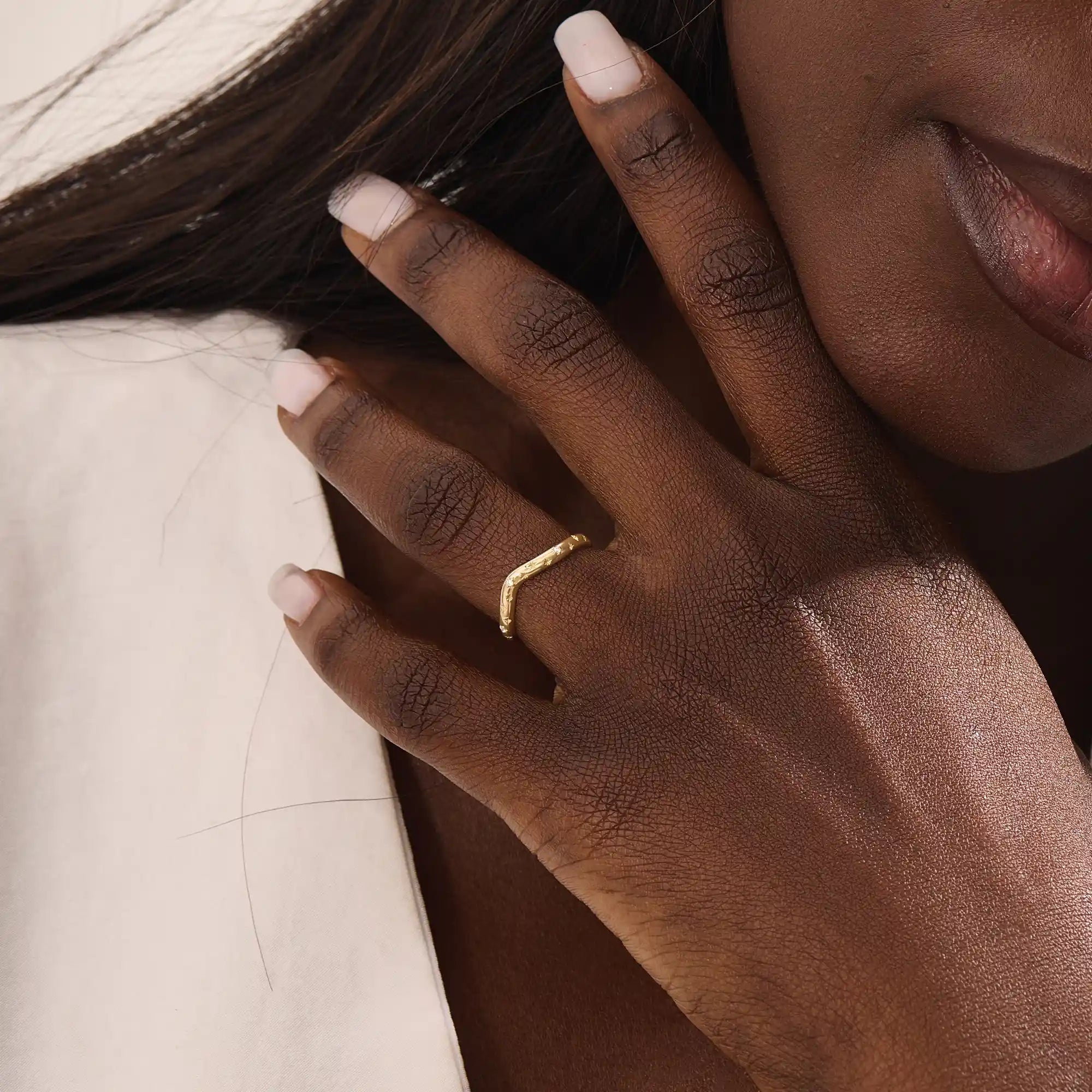 Model wears a celestial curve ring in 14k gold with sparkling moissanite stars. A whimsical and radiant stacking piece for a magical touch.

