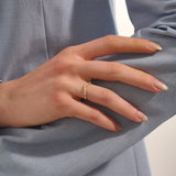 Model wears a celestial curve ring in 14k gold with sparkling moissanite stars. A whimsical and radiant stacking piece for a magical touch.