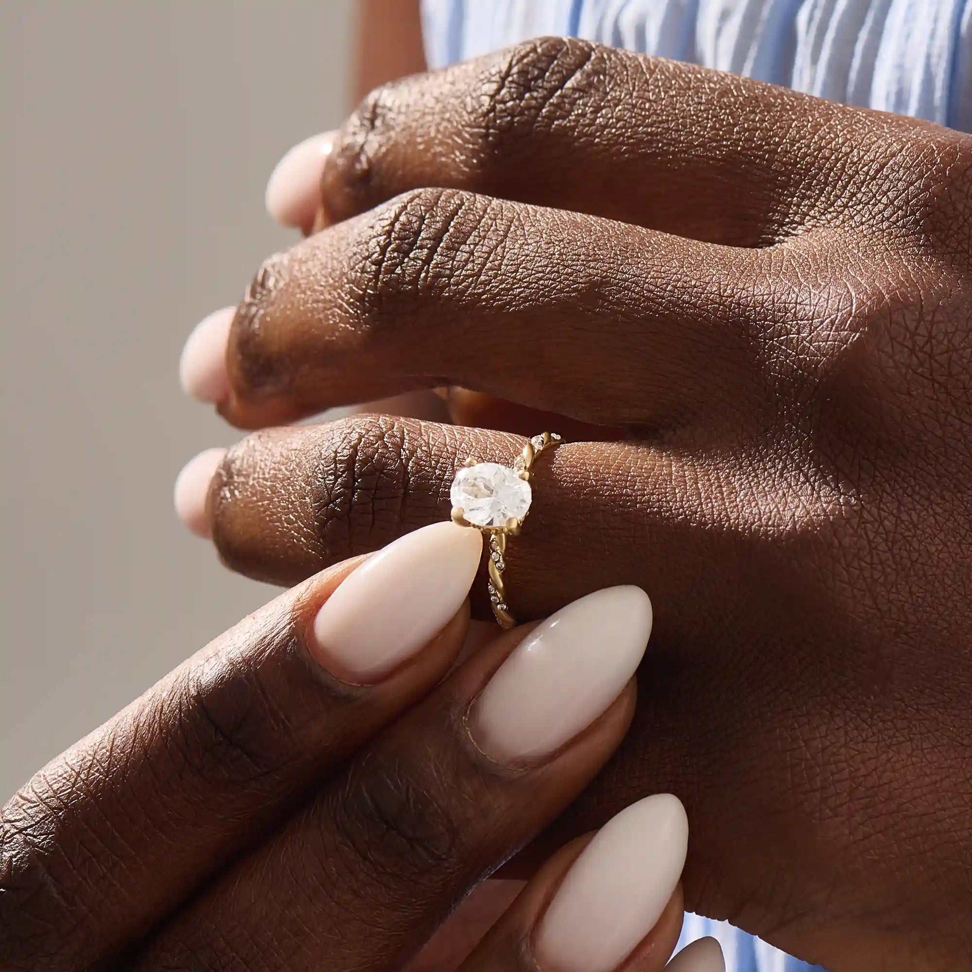 Model wears a chunky solitaire oval moissanite engagement ring in 14k solid gold. Minimalist yet bold bridal style.