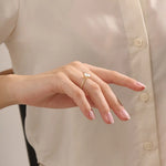 Model wears a chunky solitaire oval moissanite engagement ring in 14k solid gold. Minimalist yet bold bridal style.