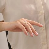 Model wears a chunky solitaire oval moissanite engagement ring in 14k solid gold. Minimalist yet bold bridal style.