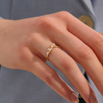 Model wears a curved 14k gold nesting ring with scattered moissanites. A delicate stacking piece that adds soft brilliance to any ring stack.