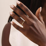Model wears a dainty curved gold ring with beaded texture and a tiny moissanite. Minimalist and feminine, ideal for layering.