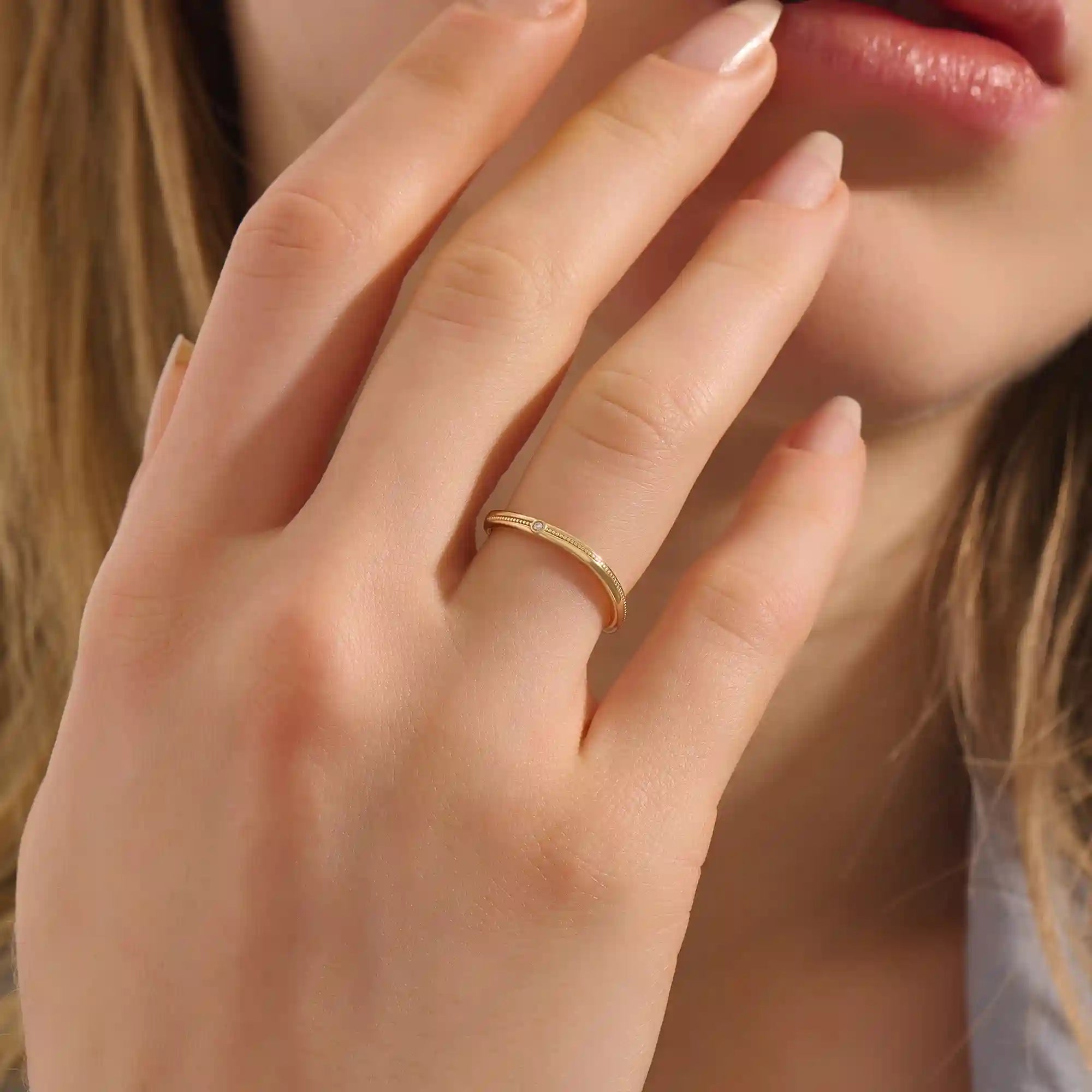 Model wears a dainty curved gold ring with beaded texture and a tiny moissanite. Minimalist and feminine, ideal for layering.
