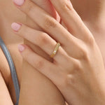 Model wears a simple 14k gold pinky signet ring with a solo moissanite accent. A contemporary and elegant piece for subtle statement style.