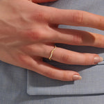 Model wears a slim 14k gold curvy band ring adorned with small moissanites. Perfect for layering or wearing solo as a subtle statement.