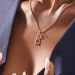 Model wears a slim 14k gold initial necklace featuring dainty moissanites. Elegant and minimal, perfect for layering or gifting.