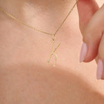 Model wears a slim 14k gold initial necklace featuring dainty moissanites. Elegant and minimal, perfect for layering or gifting.