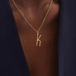 Model wears a slim 14k gold initial necklace featuring dainty moissanites. Elegant and minimal, perfect for layering or gifting.