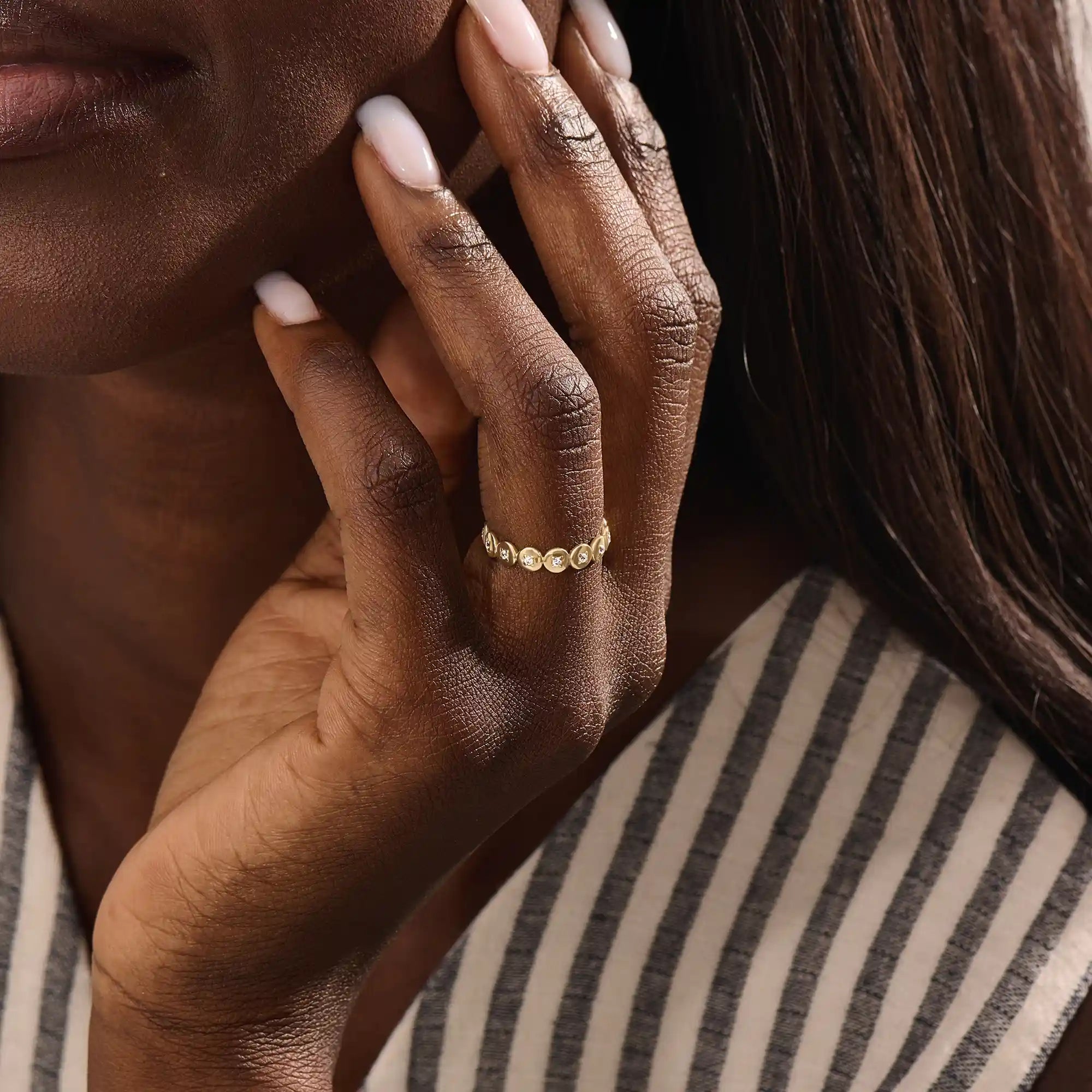 Model wears a striking 14k gold eternity ring with linked circle motifs. Perfect as a meaningful band or a modern statement ring.