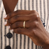Model wears a striking 14k gold eternity ring with linked circle motifs. Perfect as a meaningful band or a modern statement ring.