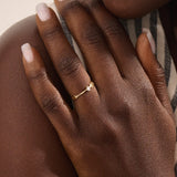 Model wears a uniquely designed 14k gold promise ring with a solo moissanite centerpiece. A stylish and meaningful symbol of commitment.