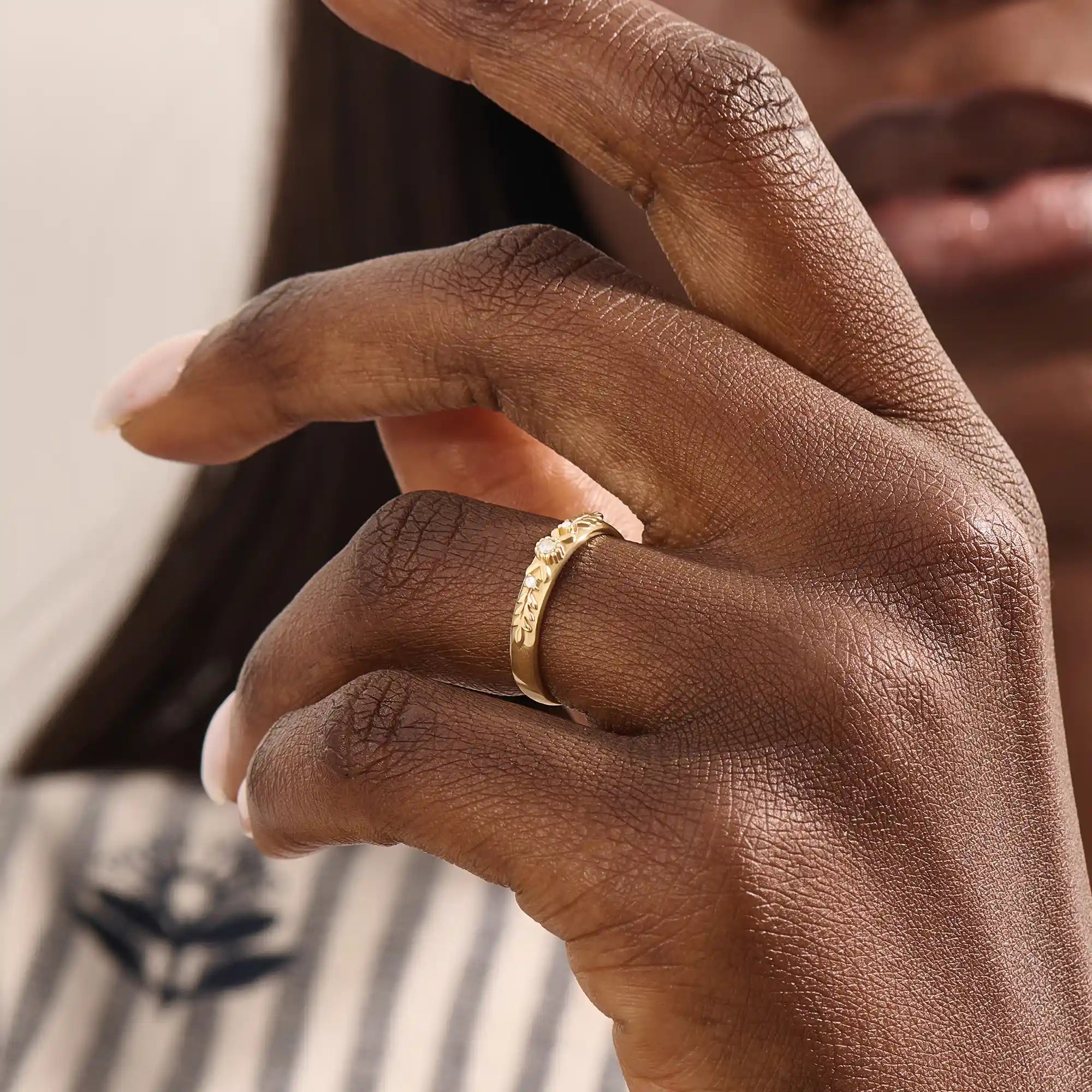 Model wears a vintage design 14k gold leaf band promise ring featuring detailed leaf engravings. Perfect for meaningful everyday wear or gifting.