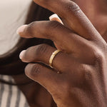 Model wears a vintage design 14k gold leaf band promise ring featuring detailed leaf engravings. Perfect for meaningful everyday wear or gifting.