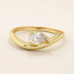 Pear cut moissanite solitaire engagement ring on a curved 14k solid gold band, minimalist design with a modern twist.