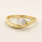Pear cut moissanite solitaire engagement ring on a curved 14k solid gold band, minimalist design with a modern twist.