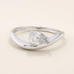 Pear cut moissanite solitaire engagement ring on a curved 14k solid gold band, minimalist design with a modern twist.