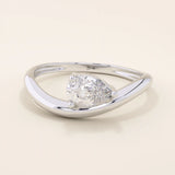 Pear cut moissanite solitaire engagement ring on a curved 14k solid gold band, minimalist design with a modern twist.