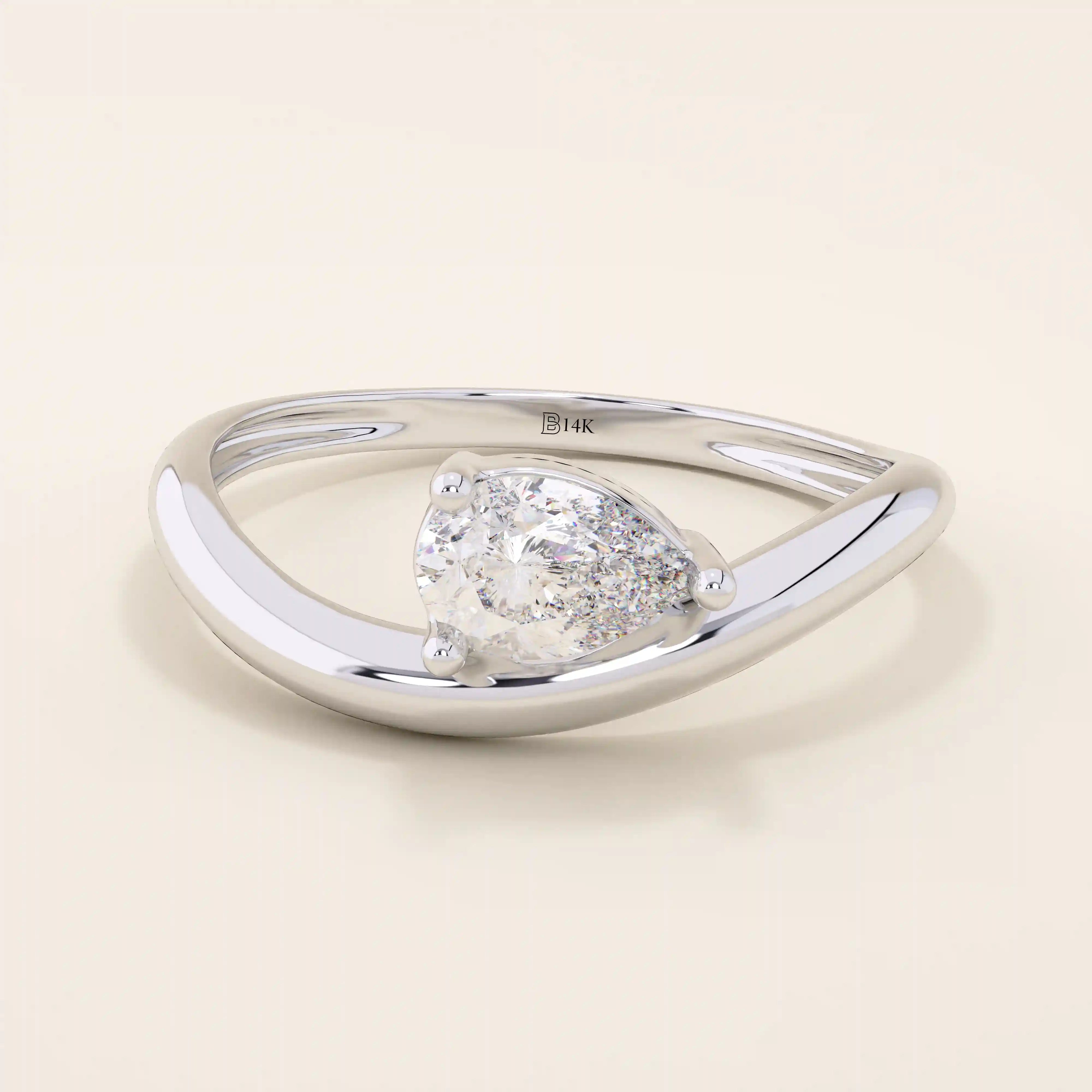 Pear cut moissanite solitaire engagement ring on a curved 14k solid gold band, minimalist design with a modern twist.