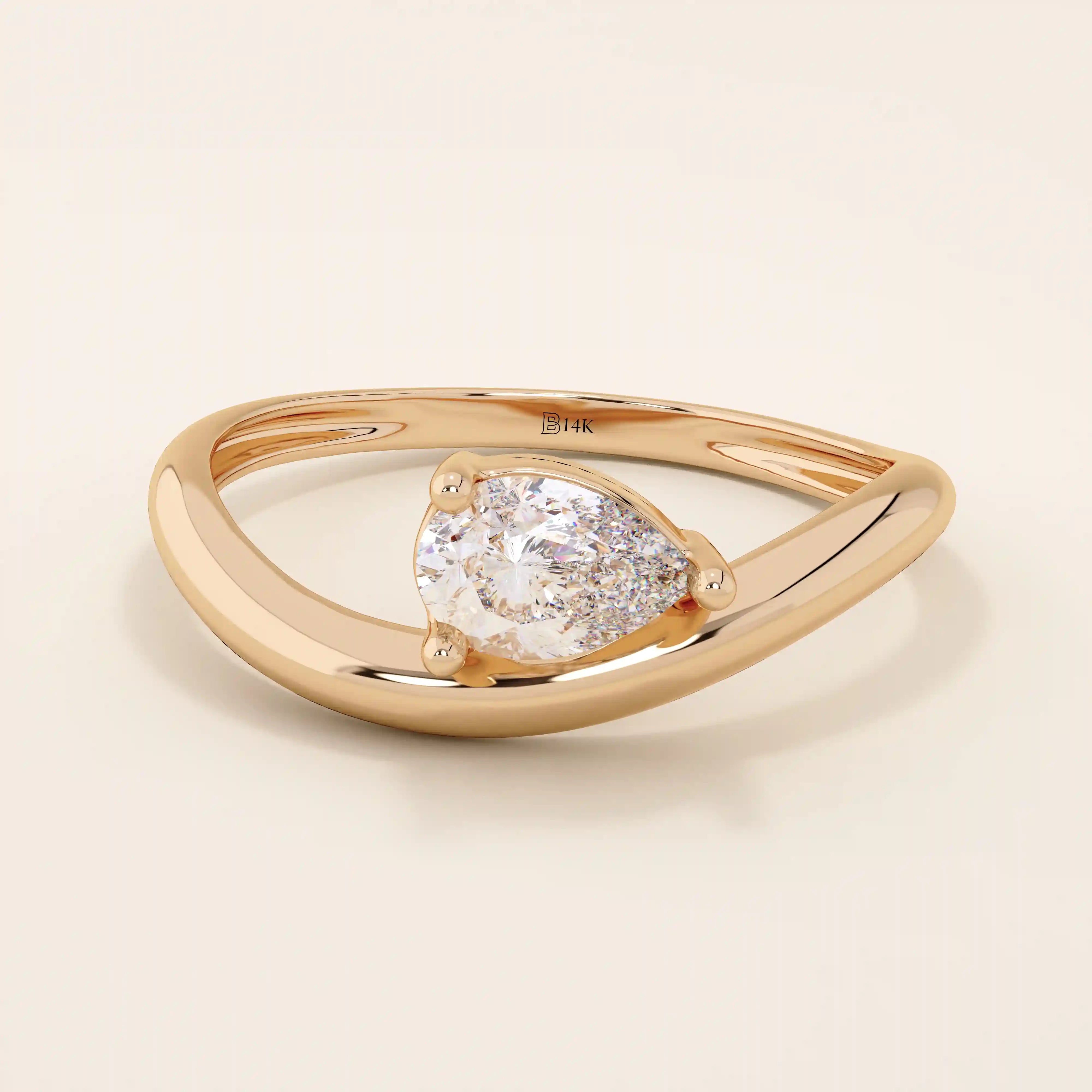 Pear cut moissanite solitaire engagement ring on a curved 14k solid gold band, minimalist design with a modern twist.