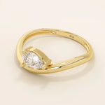 Pear cut moissanite solitaire engagement ring on a curved 14k solid gold band, minimalist design with a modern twist.