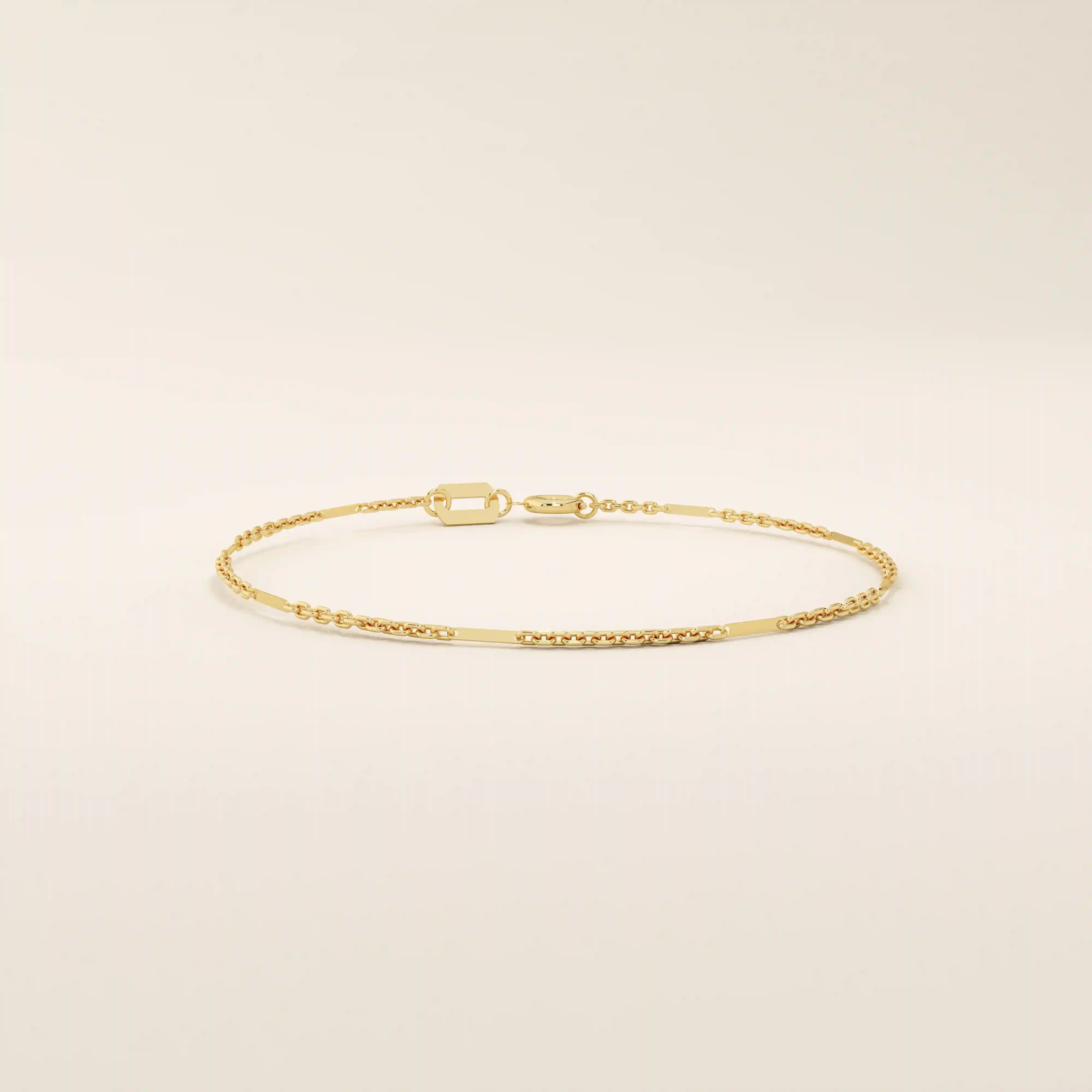 Side angle of a 14k solid yellow gold flat bar chain bracelet, showing the slim rectangular links and the light-catching polished finish.
