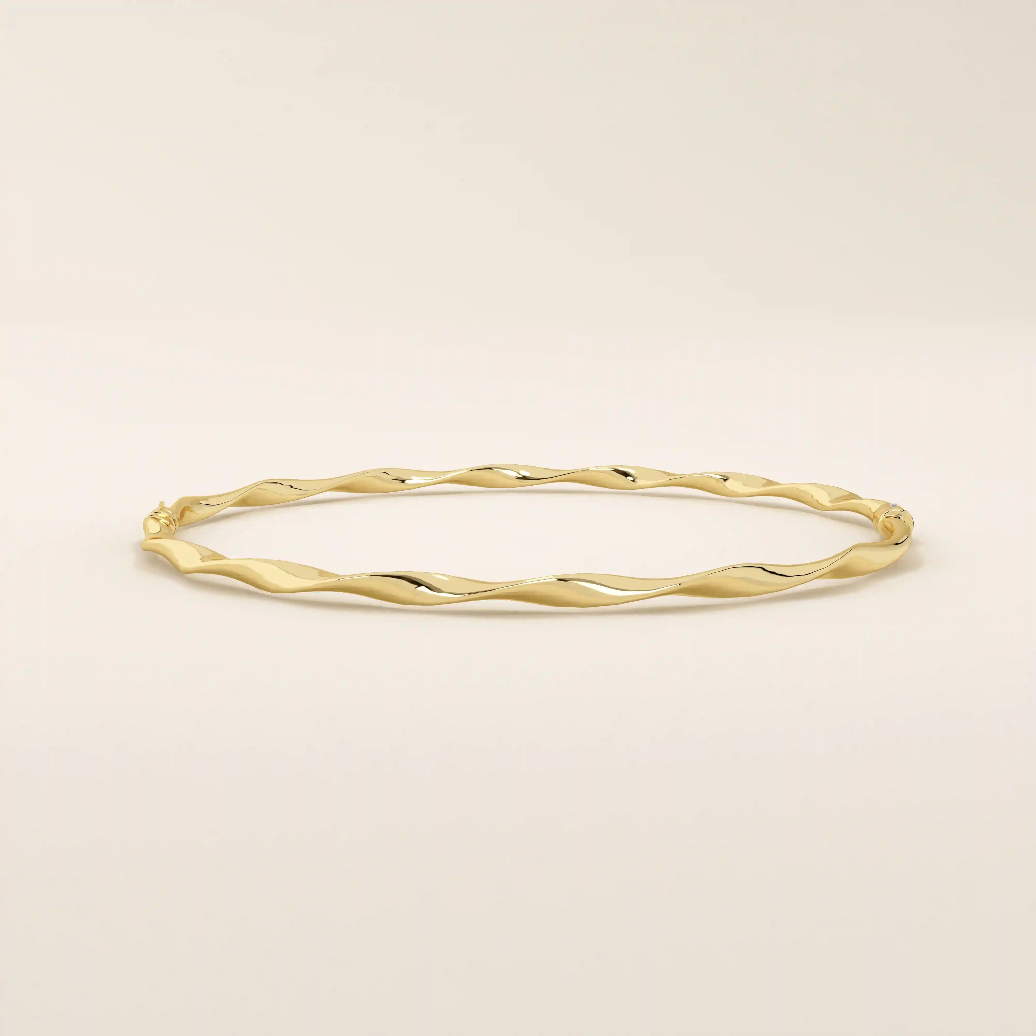 Side angle of a 14k solid yellow gold twist bangle bracelet, highlighting its smooth wave-like curves and reflective surface.
