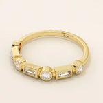 Side angle view of a 14k solid yellow gold band with alternating baguette cut and round brilliant cut moissanite stones in a modern bezel setting, stylish and refined bridal jewelry
