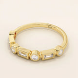 Side angle view of a 14k solid yellow gold band with alternating baguette cut and round brilliant cut moissanite stones in a modern bezel setting, stylish and refined bridal jewelry
