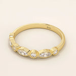 Side angle view of a 14k solid yellow gold band with alternating marquise cut and round brilliant cut moissanite stones in a smooth bezel setting, sophisticated wedding or stacking ring
