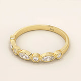Side angle view of a 14k solid yellow gold band with alternating marquise cut and round brilliant cut moissanite stones in a smooth bezel setting, sophisticated wedding or stacking ring
