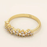 Side angle view of a 14k solid yellow gold band with clusters of round brilliant cut moissanite stones in prong settings, elegant and textured bridal jewelry
