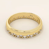 Side angle view of a 14k solid yellow gold band with round brilliant cut moissanite stones in a single row and bead accents, sophisticated and minimal bridal jewelry
