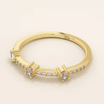 Side angle view of a 14k solid yellow gold band with three baguette cut moissanite stones and pavé set round moissanite accents, minimal and refined bridal jewelry
